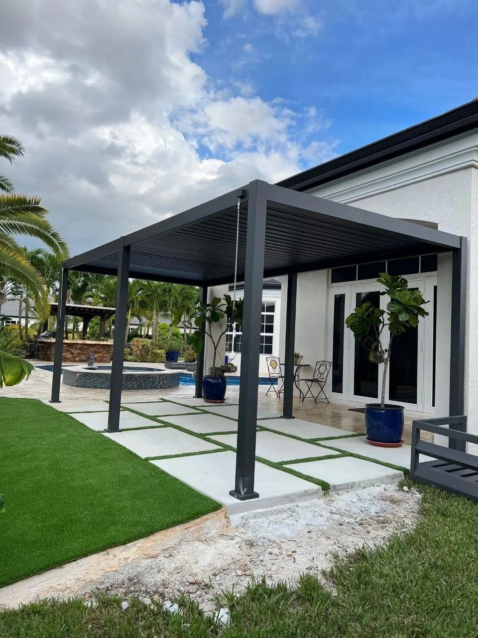 Concrete patio with artificial grass and pergola in Davie, Florida