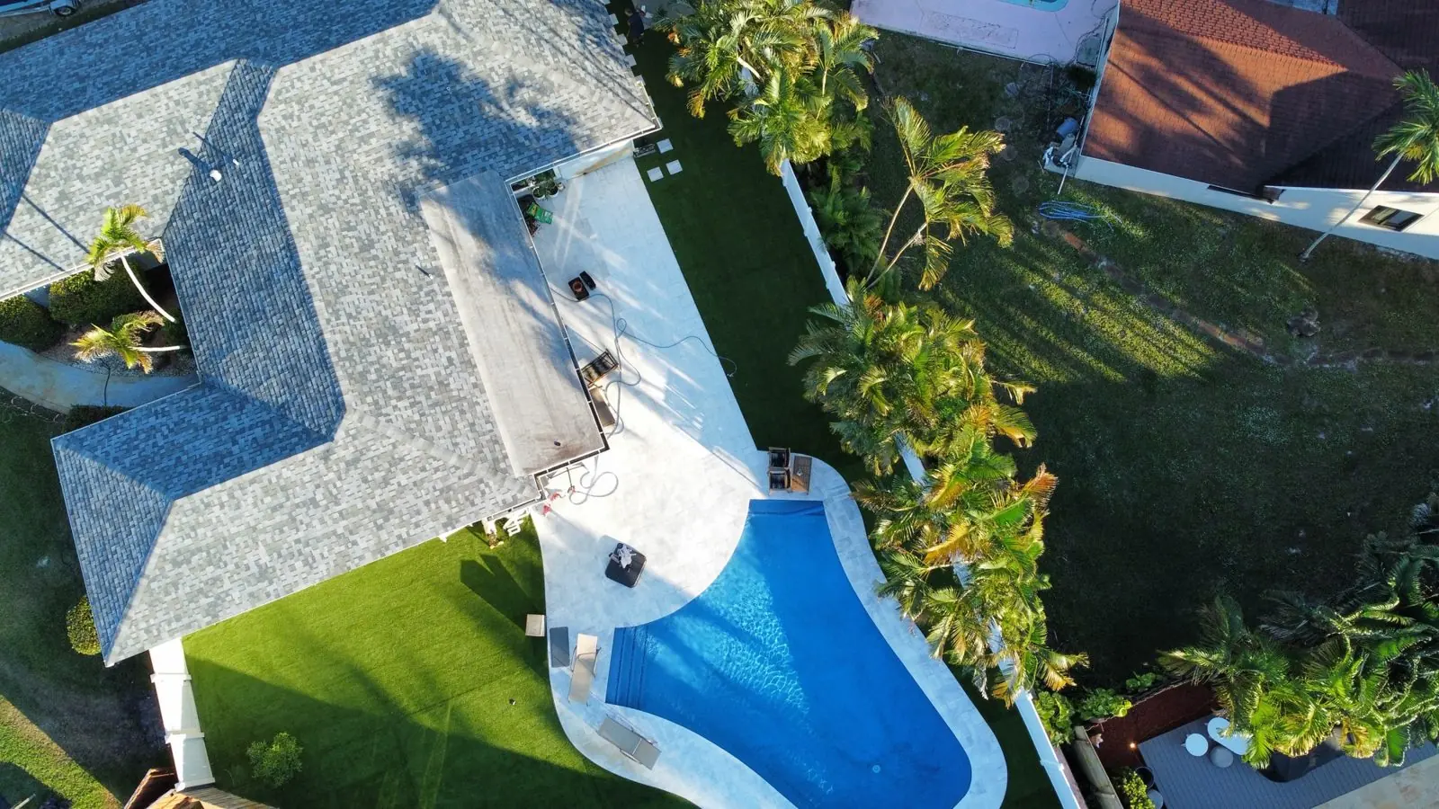 Artificial turf around a backyard pool, aerial view by Concrete Solutions Today, Broward County, FL