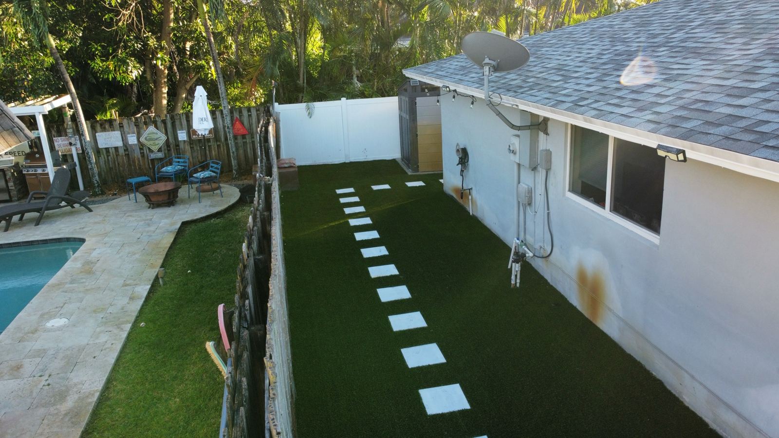 Artificial turf side yard with concrete stepping pads by Concrete Solutions Today, Broward County, FL