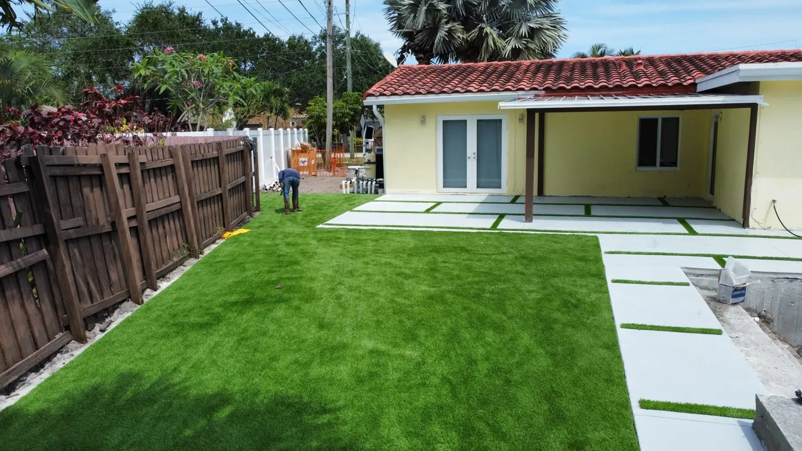 Backyard artificial turf lawn with concrete walkway pads by Concrete Solutions Today, Broward County, FL