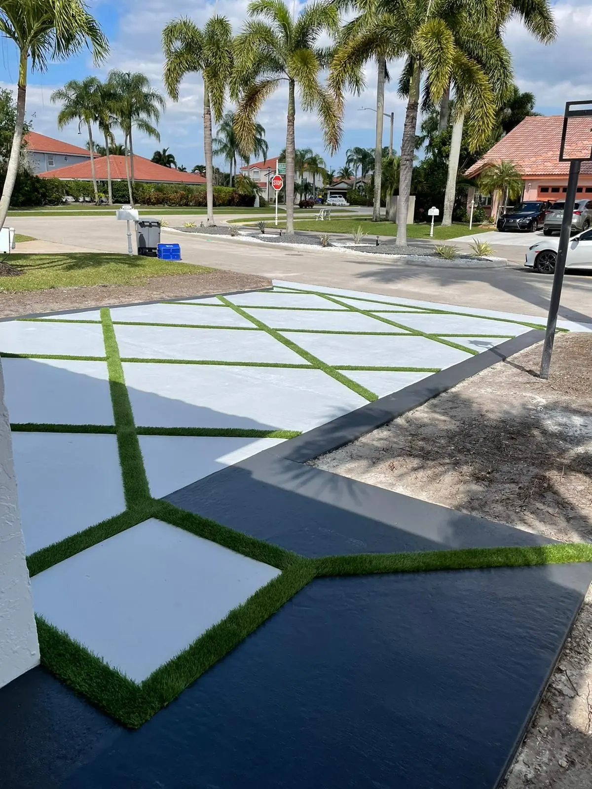 Geometric concrete and turf-joint driveway with a dark border by Concrete Solutions Today, Boca Raton, FL