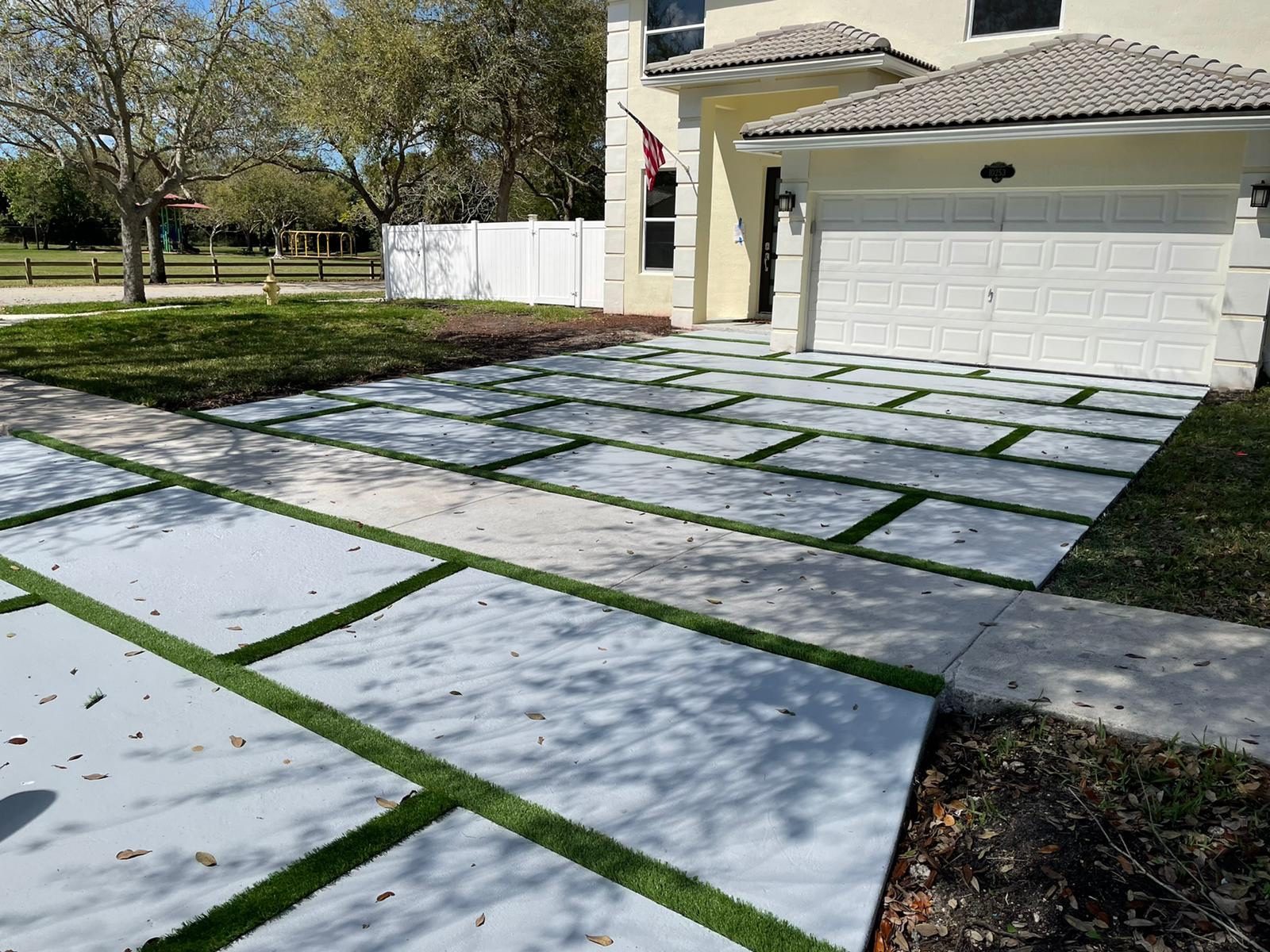 Modern concrete panel driveway with artificial turf joints built by Concrete Solutions Today in Boca Raton, FL