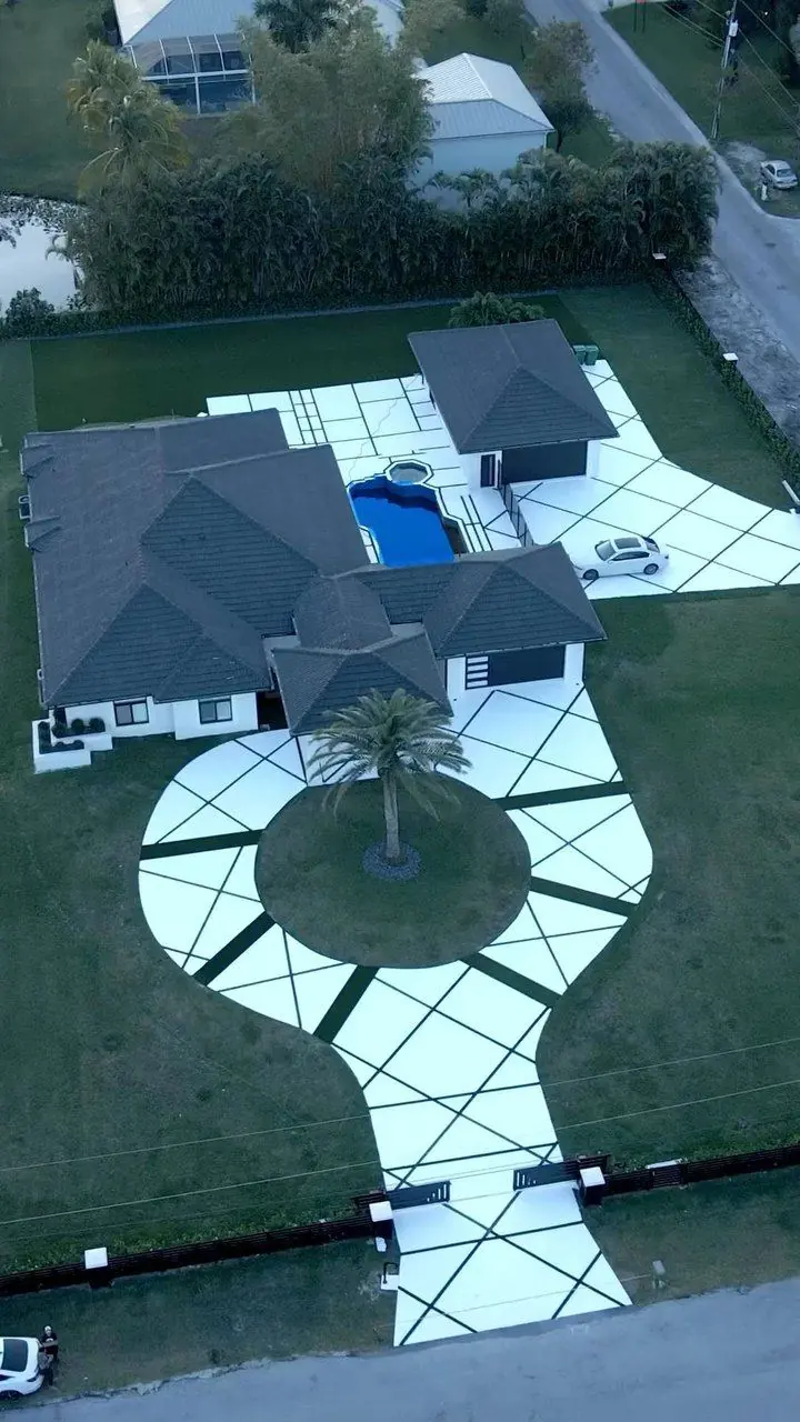 Circular concrete driveway with diagonal artificial grass lines and a palm island by Concrete Solutions Today, Davie, FL