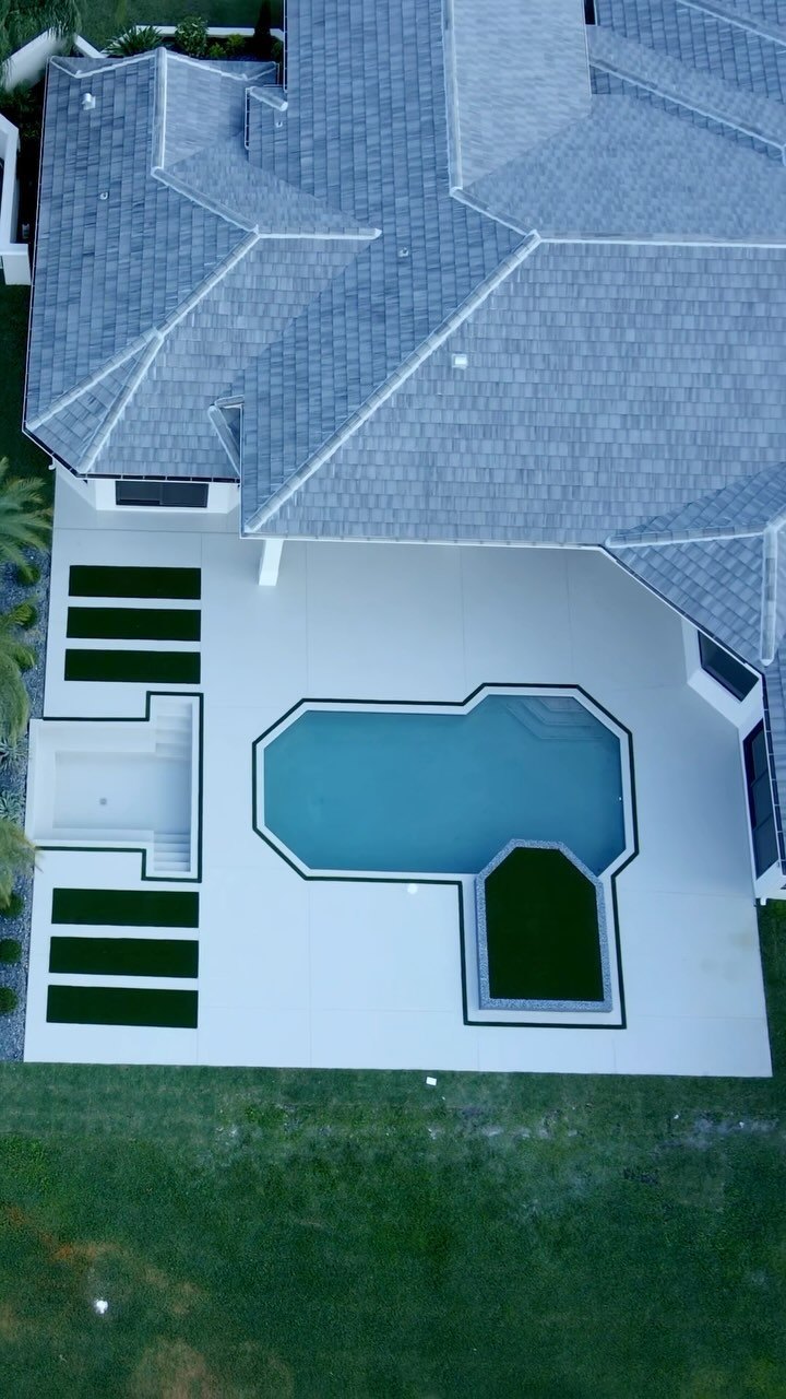Aerial view of a Davie home with a California minimalist concrete pool deck, sunken lounge, and artificial grass accents