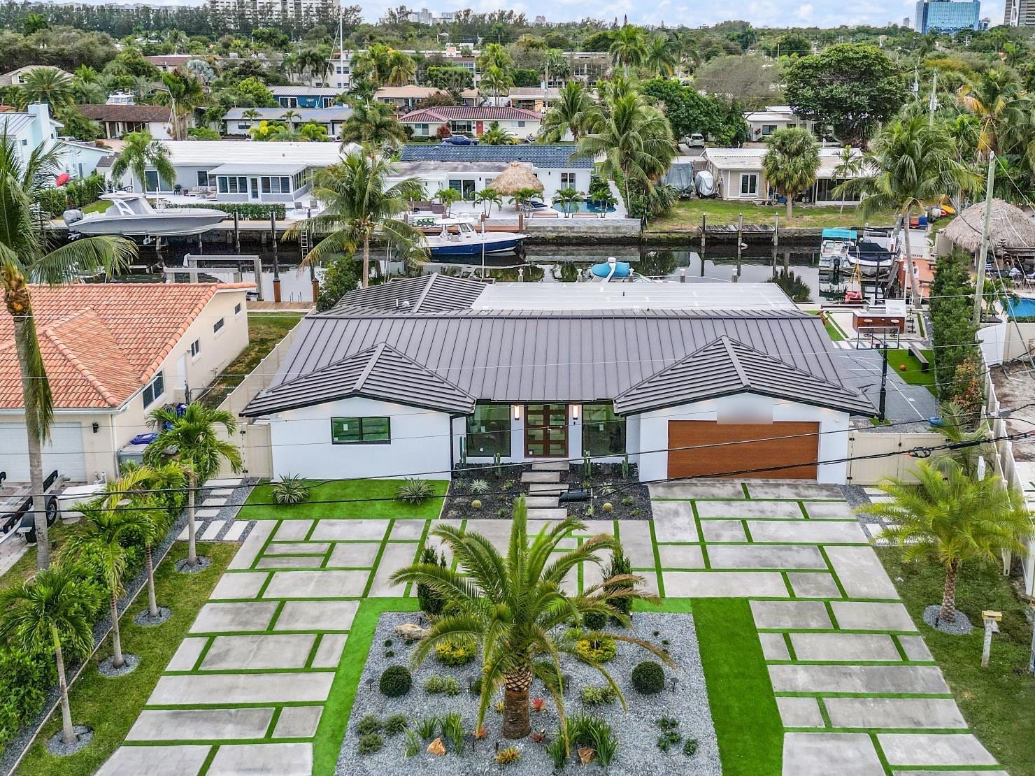 Aerial view of a waterfront Fort Lauderdale home with a concrete and artificial turf panel driveway by Concrete Solutions Today