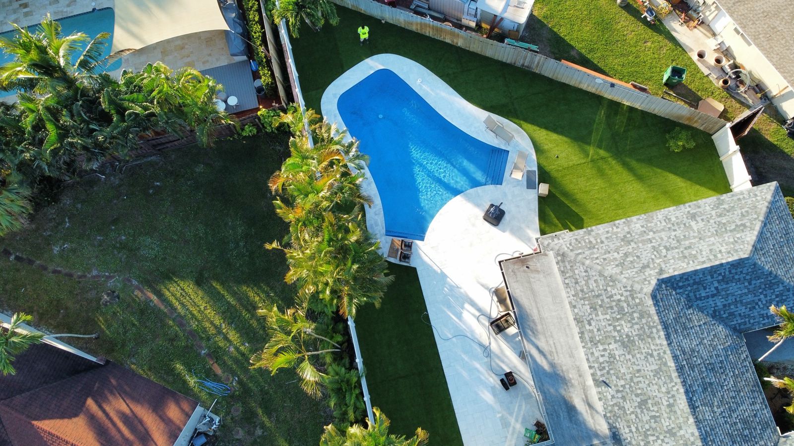 Freeform pool with a white concrete deck, Plantation or Coral Springs, Florida