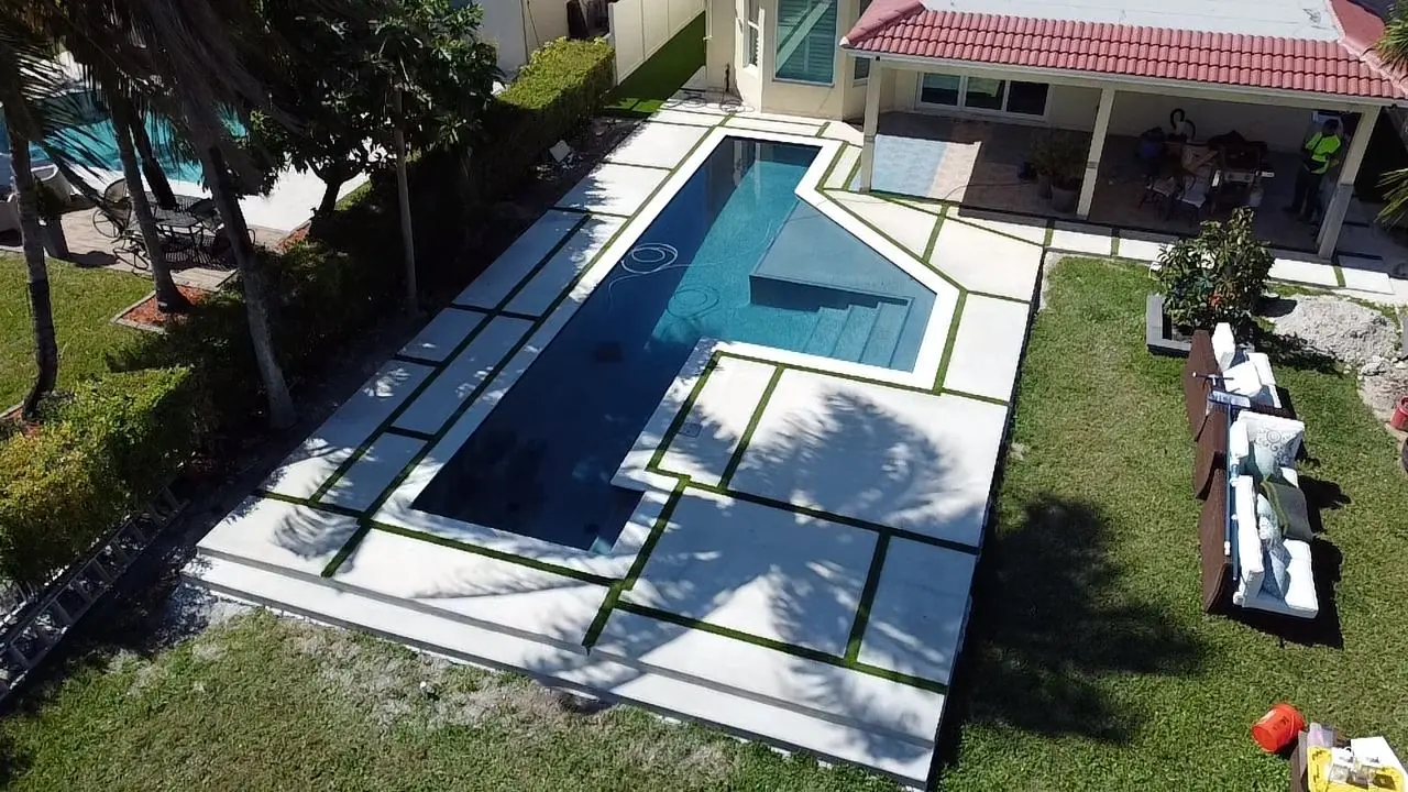 Pool deck with large concrete slabs and grass joints, Plantation or Coral Springs, Florida