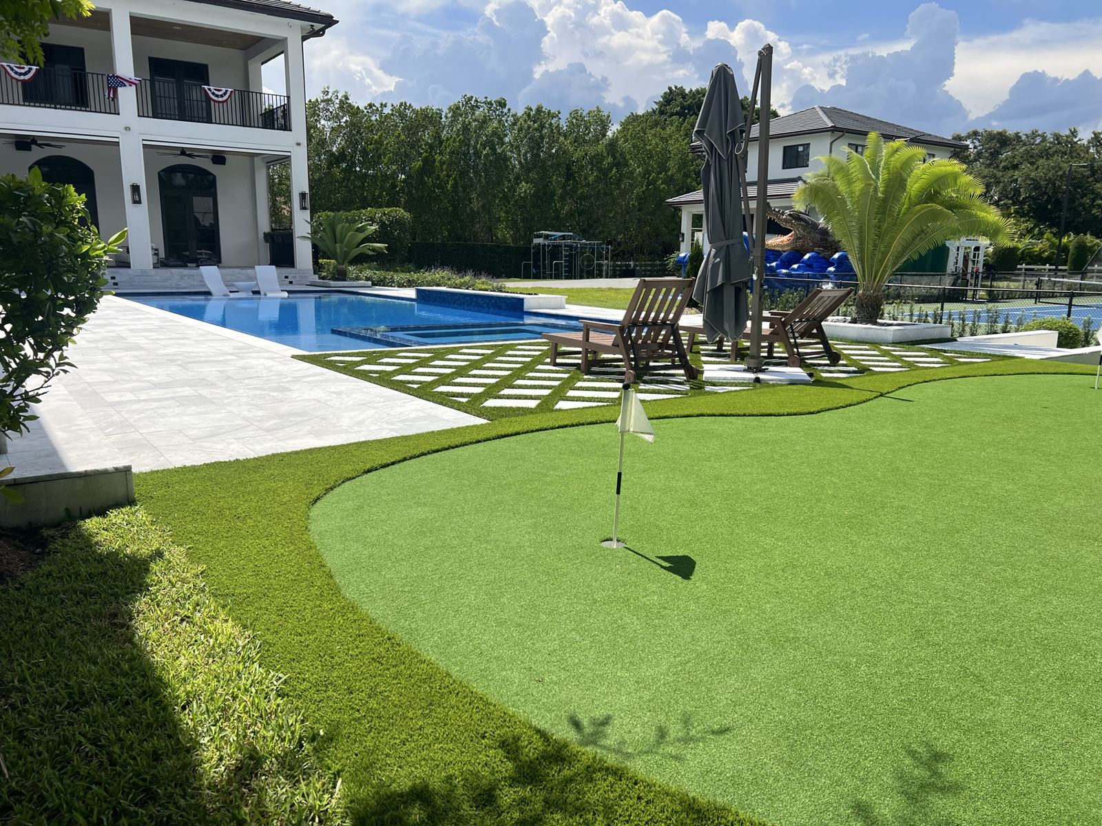 Artificial turf putting green beside the pool by Concrete Solutions Today, Broward County, FL