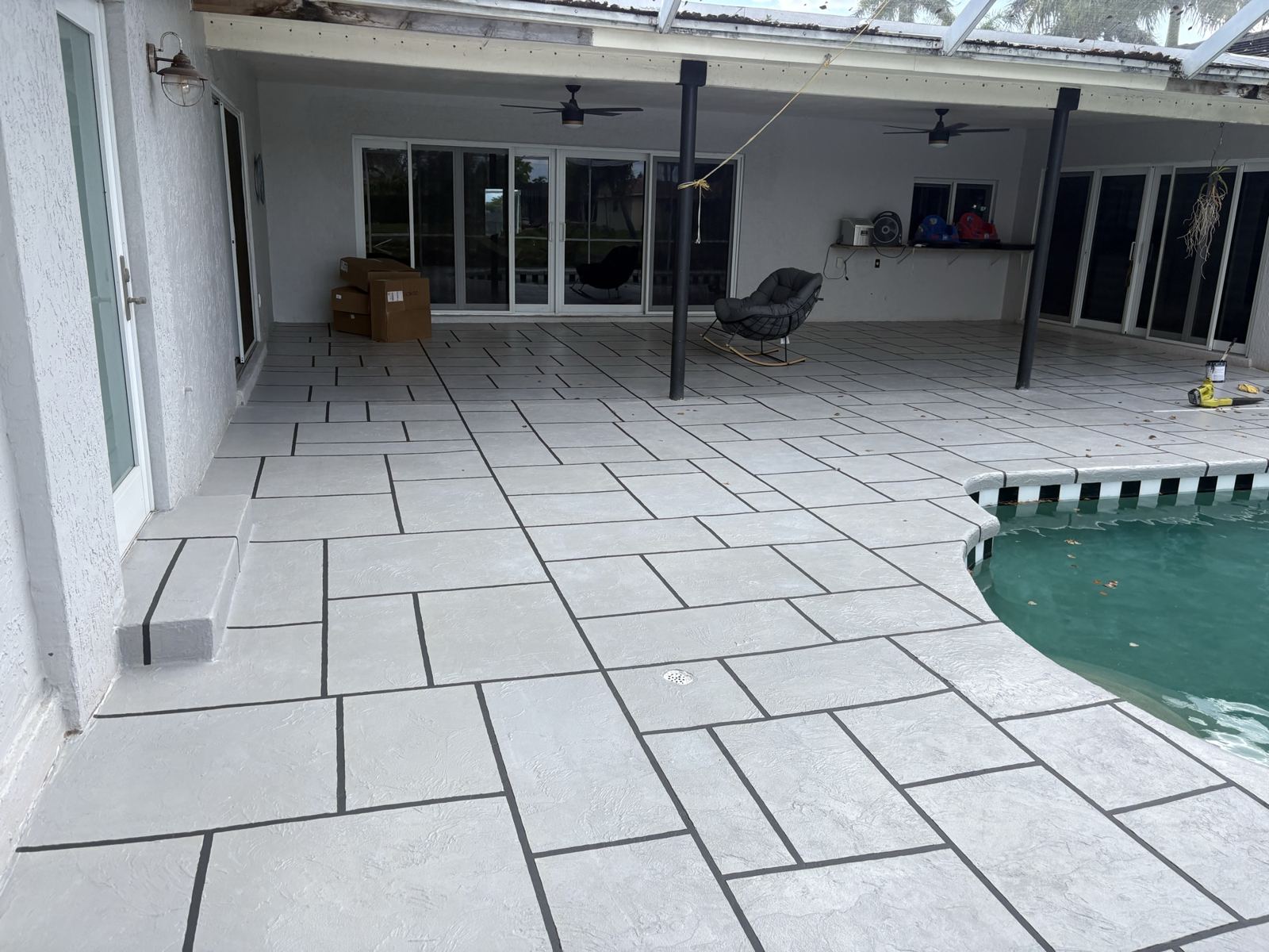 Resurfaced covered patio with a tile-pattern finish by Concrete Solutions Today, Broward County, FL