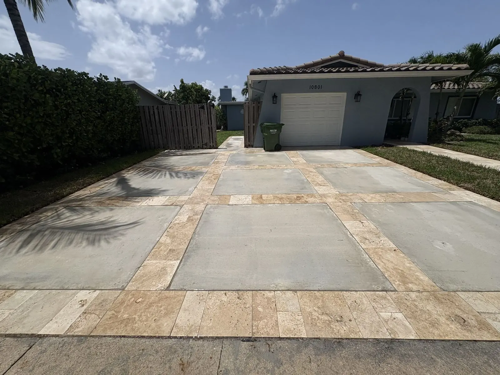 Concrete driveway with travertine-style paver borders by Concrete Solutions Today, Broward County, FL