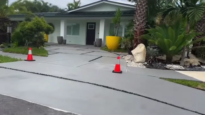 Concrete driveway panels with black rock joints in front of the home by Concrete Solutions Today, Wilton Manors, FL